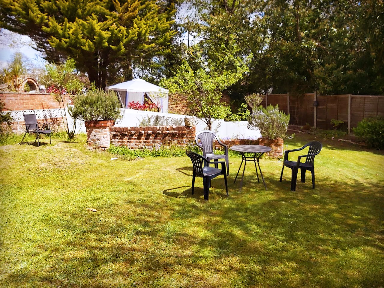 The garden containing a sitting area with a table and chairs