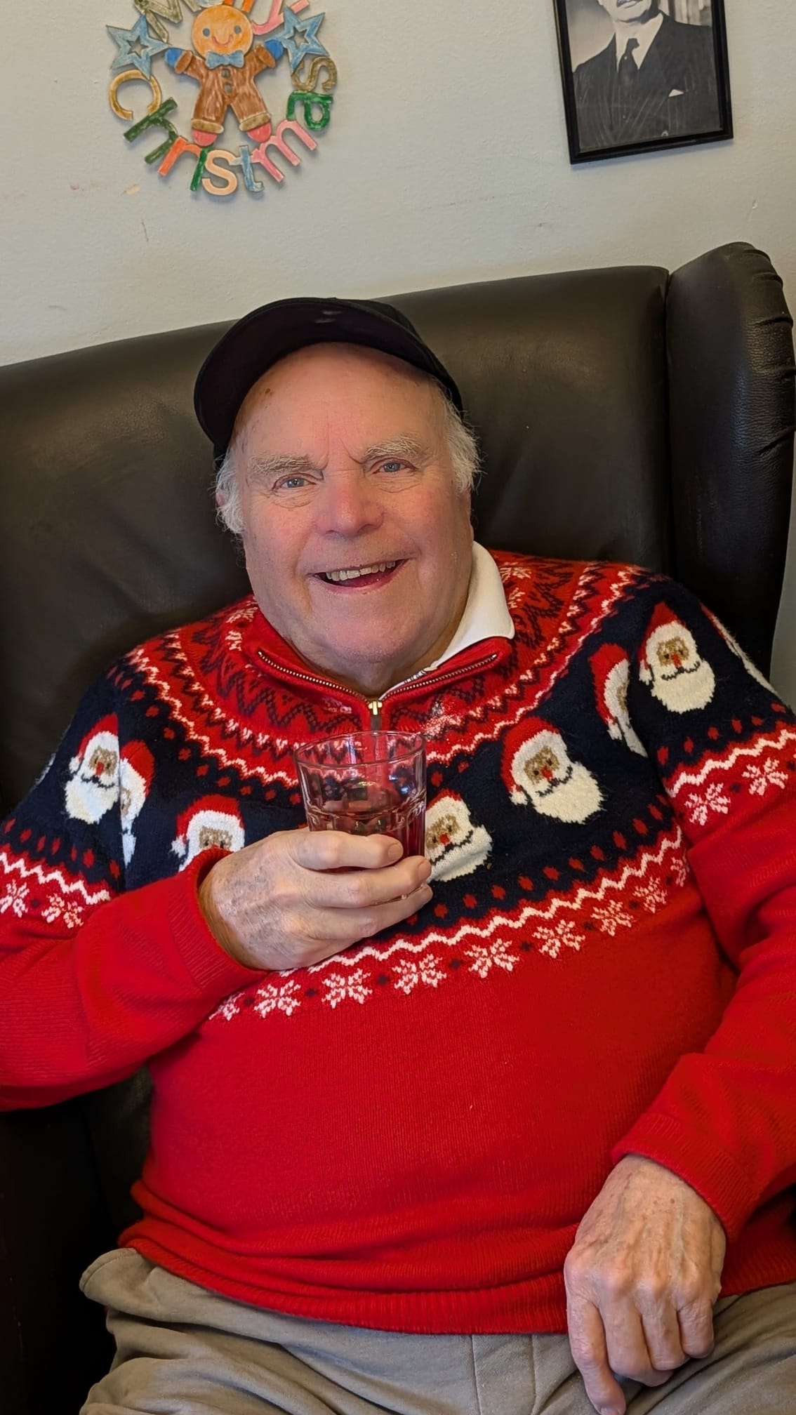 sheerwater house redsident enjpying a beverage in a comfy chair