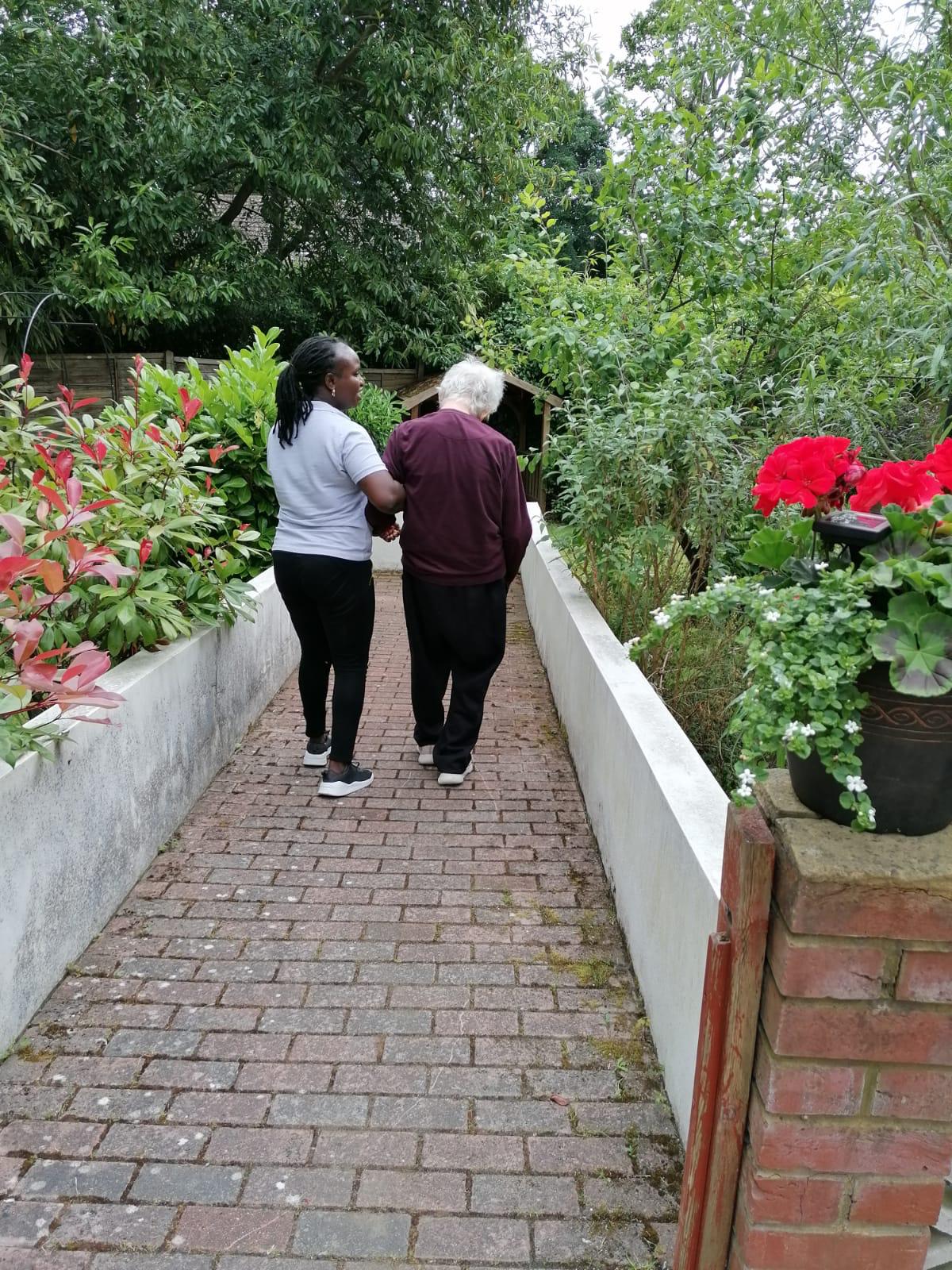resident being taken tor a walk through the local gardens